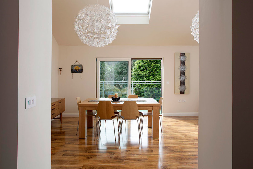 Idee per una piccola sala da pranzo aperta verso il soggiorno design con pareti bianche, parquet chiaro e nessun camino