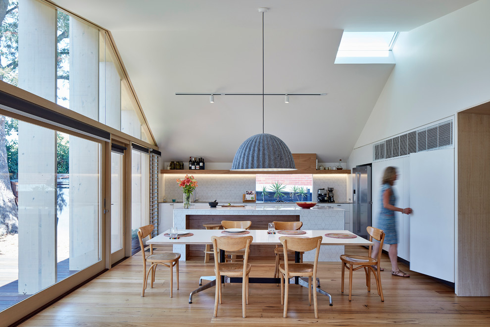 Imagen de comedor de cocina actual de tamaño medio con paredes blancas, suelo de madera clara y suelo beige