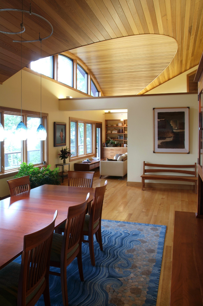 Große Moderne Wohnküche ohne Kamin mit beiger Wandfarbe, braunem Holzboden und braunem Boden in Sonstige