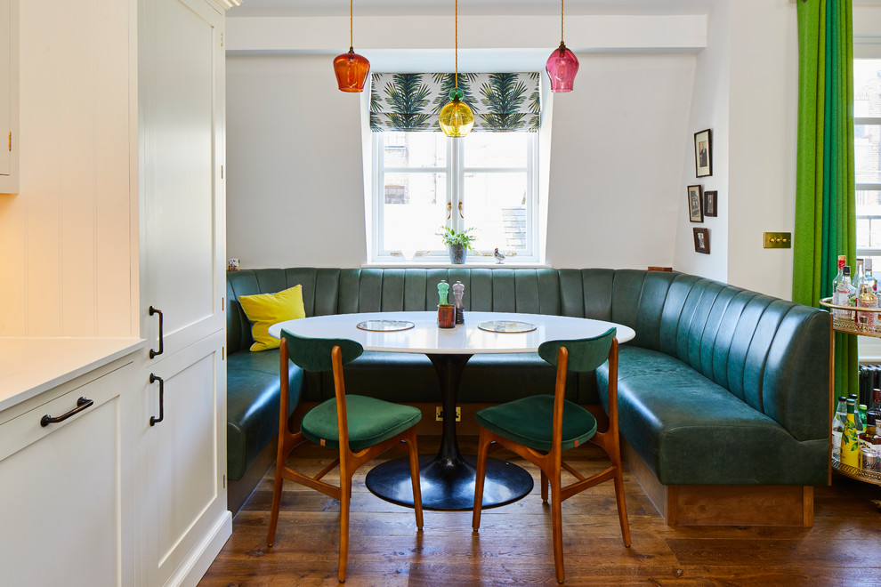 Inspiration for an eclectic dining room in London with white walls, medium hardwood flooring and brown floors.