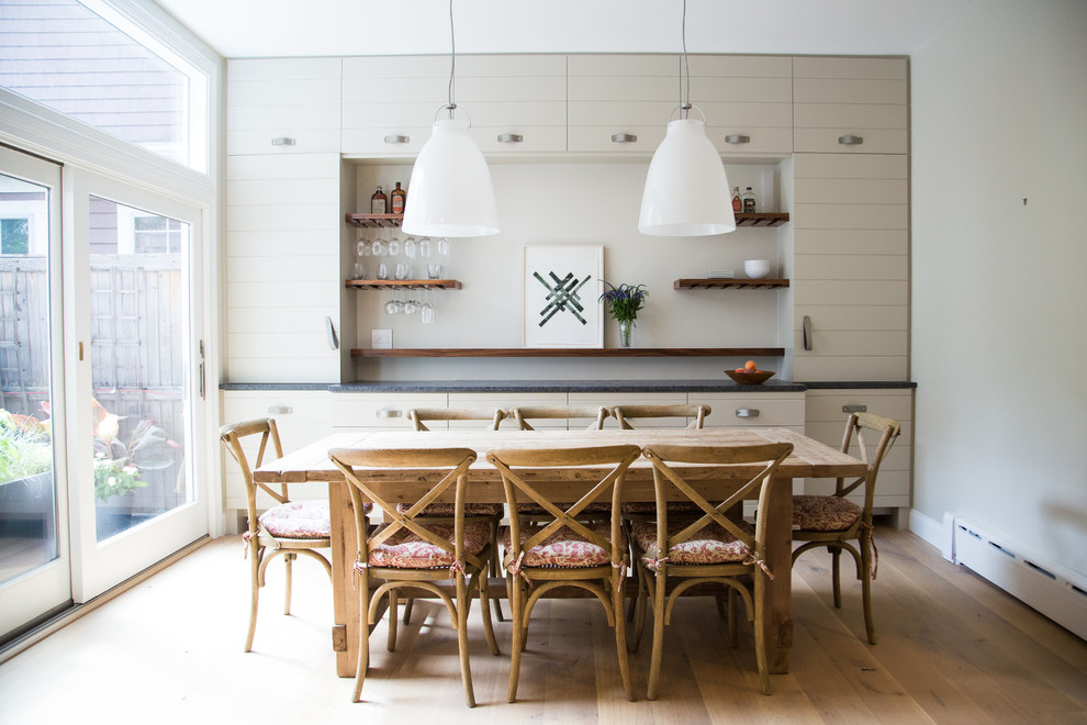Foto di una sala da pranzo aperta verso la cucina costiera di medie dimensioni con pareti grigie, parquet chiaro e nessun camino