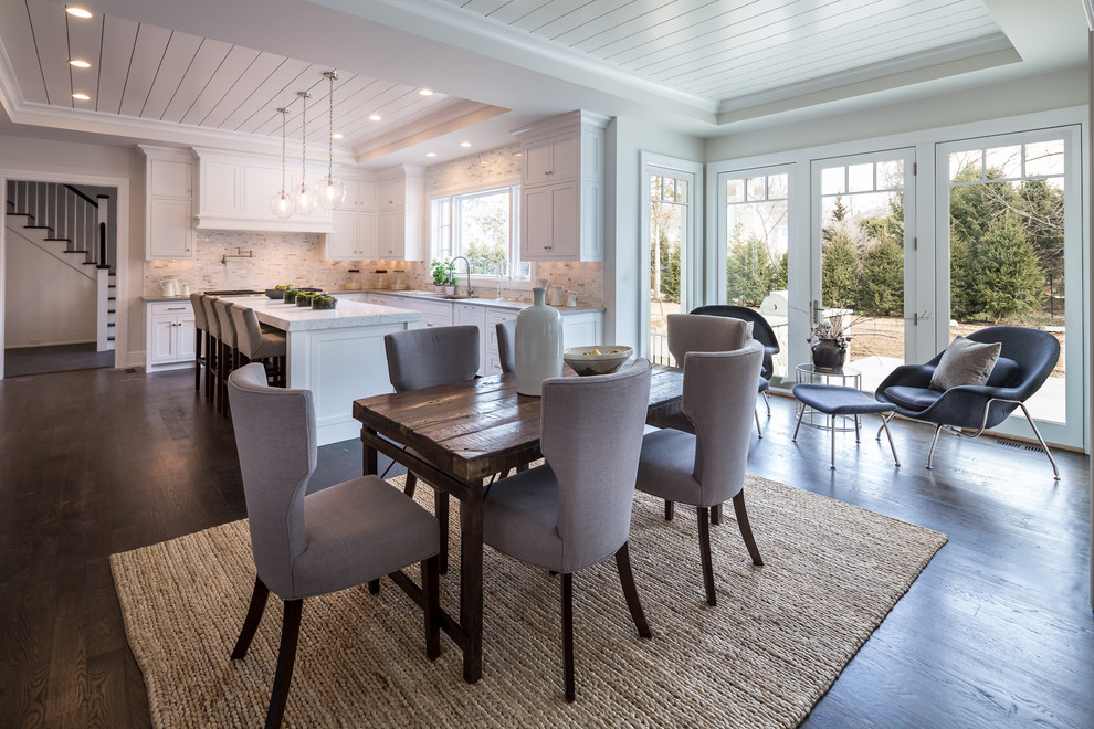 Idées déco pour une salle à manger ouverte sur la cuisine classique de taille moyenne avec un mur gris, parquet foncé, aucune cheminée et un sol marron.