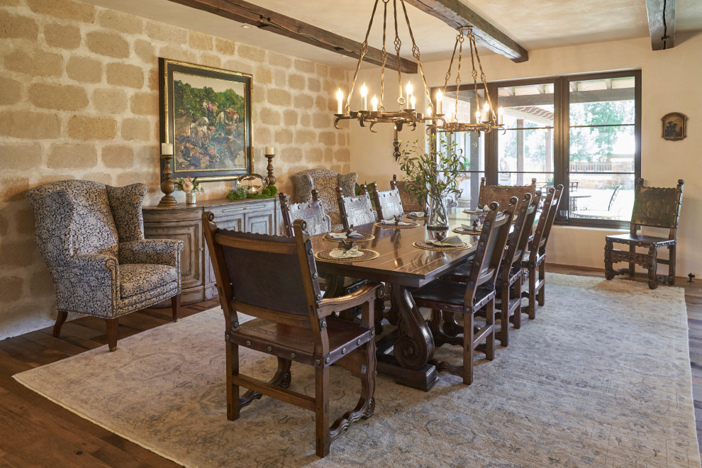 Inspiration for a southwestern medium tone wood floor, brown floor and exposed beam dining room remodel in Wichita with beige walls