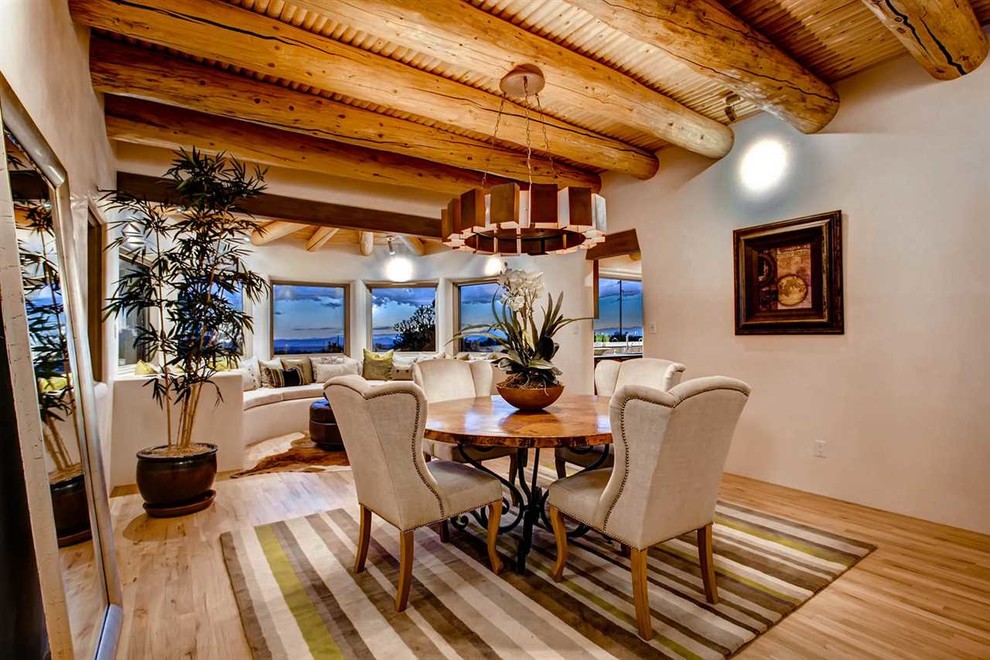 Imagen de comedor de estilo americano abierto con suelo de madera clara y paredes beige