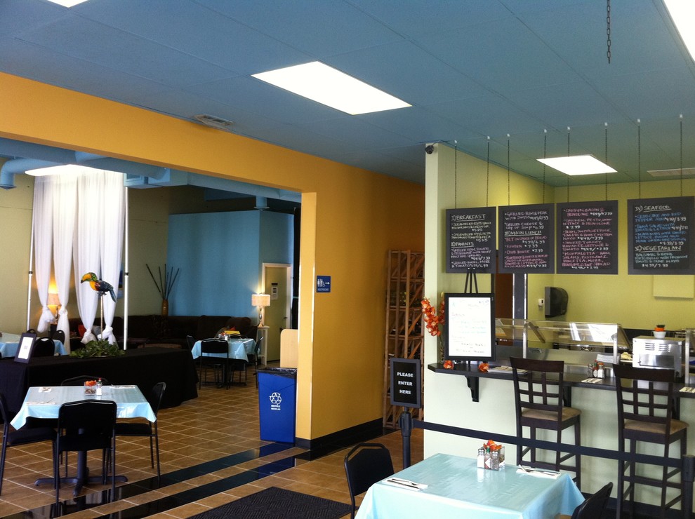 Immagine di un'ampia sala da pranzo aperta verso la cucina eclettica con pareti multicolore, pavimento con piastrelle in ceramica e nessun camino