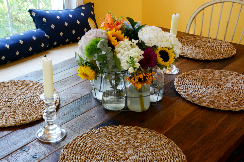 Cette photo montre une salle à manger ouverte sur la cuisine nature de taille moyenne avec un mur jaune, parquet foncé et un sol marron.