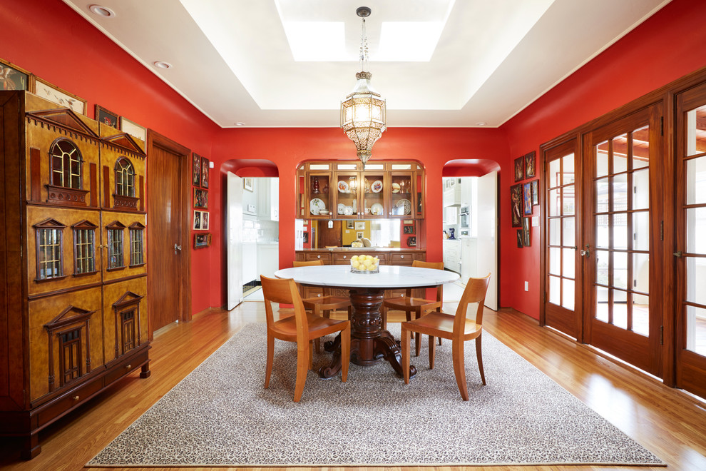 Idee per una grande sala da pranzo aperta verso la cucina chic con pavimento in legno massello medio, pareti rosse e pavimento marrone