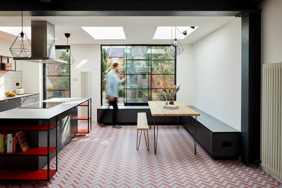 Minimalistisk inredning av ett litet kök med matplats, med vita väggar och flerfärgat golv