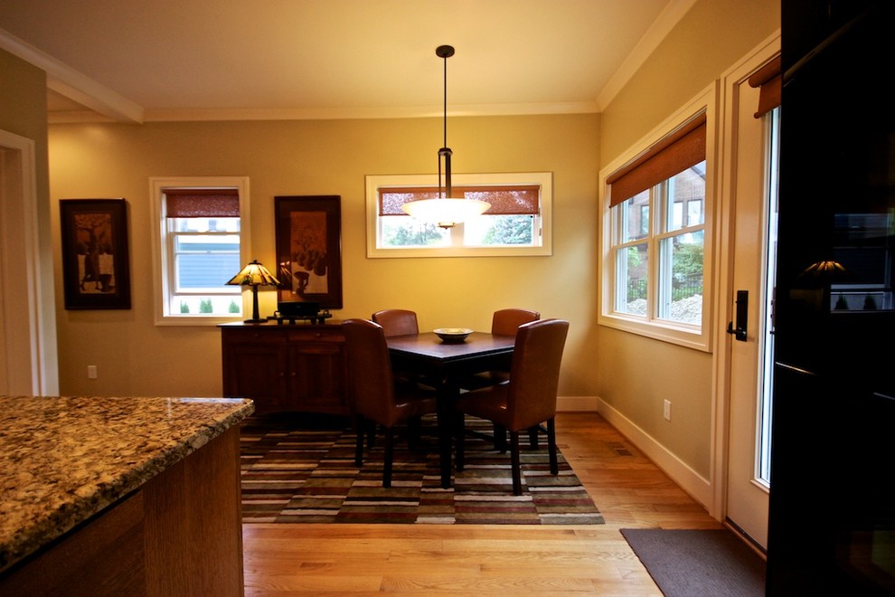 Cette image montre une petite salle à manger ouverte sur la cuisine craftsman avec un mur beige, parquet clair et aucune cheminée.