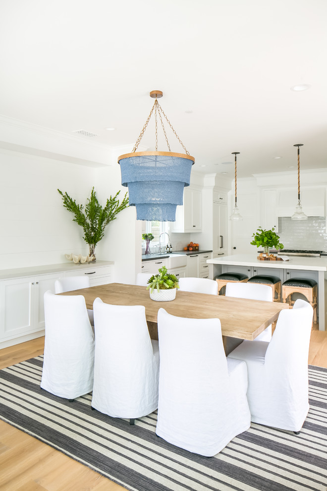 Example of a mid-sized beach style light wood floor kitchen/dining room combo design in Orange County with white walls