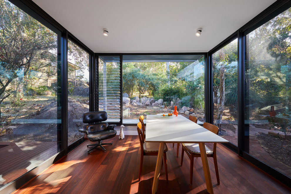 Immagine di una sala da pranzo aperta verso la cucina design di medie dimensioni con parquet scuro e pavimento rosso