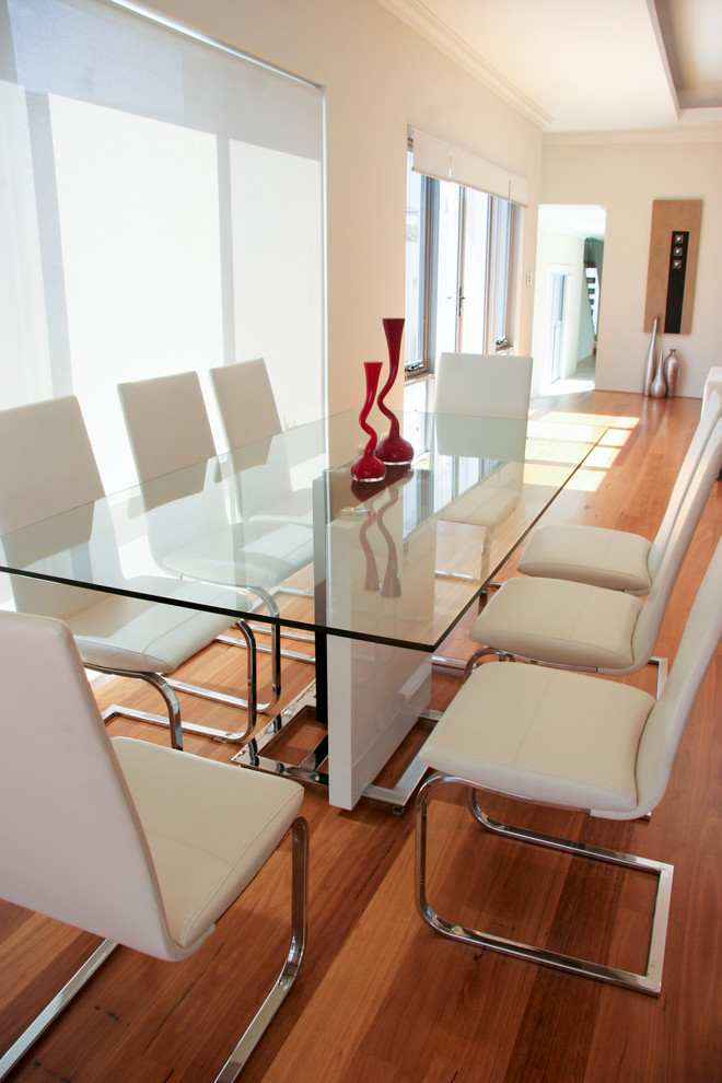 Exemple d'une salle à manger ouverte sur le salon tendance de taille moyenne avec un mur blanc, un sol en bois brun et un sol jaune.