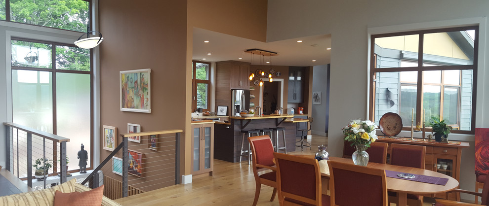 Modern inredning av en mellanstor matplats med öppen planlösning, med bruna väggar och ljust trägolv