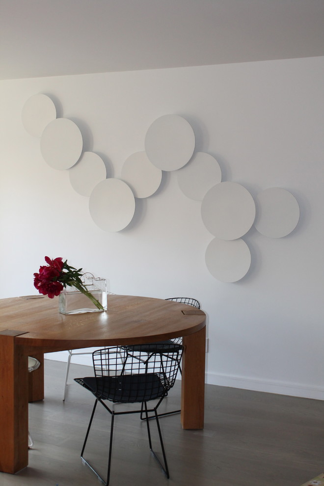 Cette image montre une salle à manger minimaliste avec un mur blanc et parquet clair.