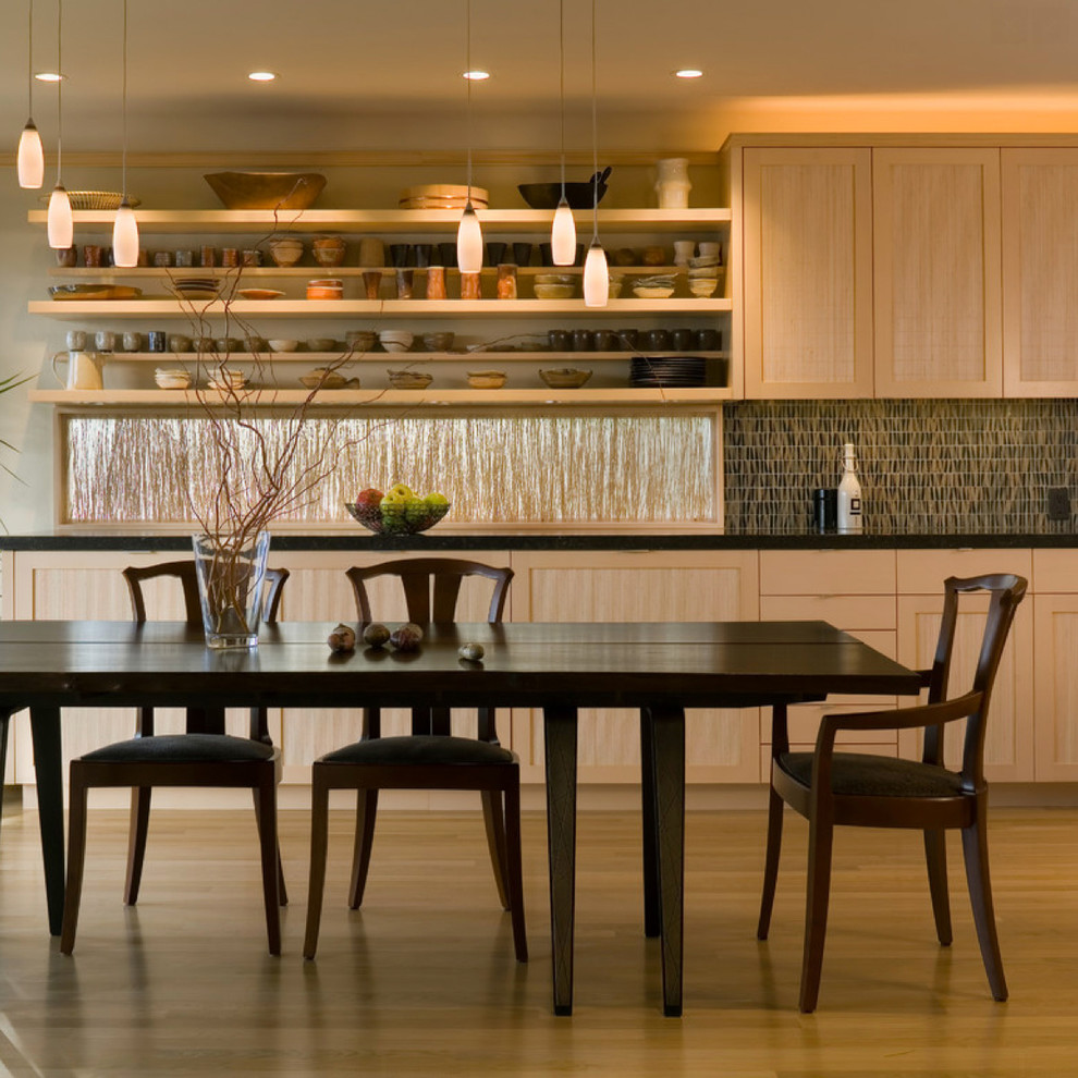 Immagine di una piccola sala da pranzo aperta verso la cucina classica con parquet chiaro
