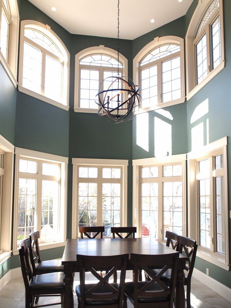 На фото: большая гостиная-столовая в стиле неоклассика (современная классика) с зелеными стенами, полом из керамической плитки и бежевым полом