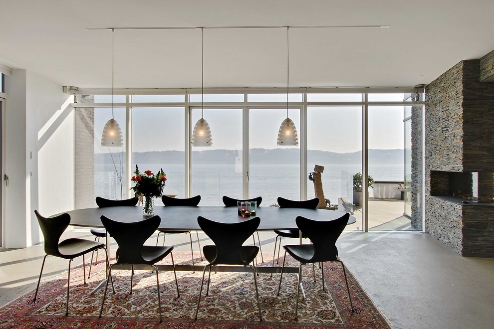 Cette photo montre une salle à manger scandinave avec sol en béton ciré et un sol gris.