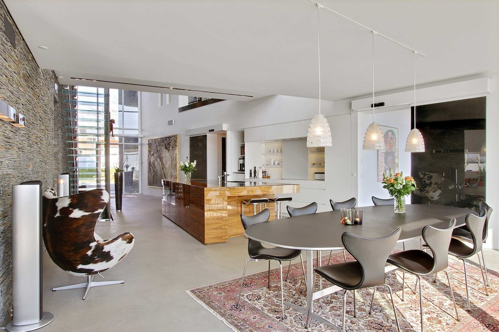 Foto di una grande sala da pranzo scandinava con pareti bianche, pavimento in cemento e pavimento grigio