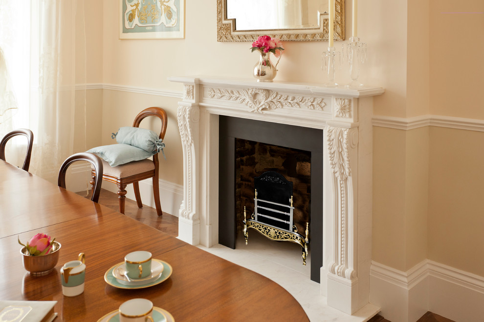 Inspiration for a classic dining room in London with a stone fireplace surround.