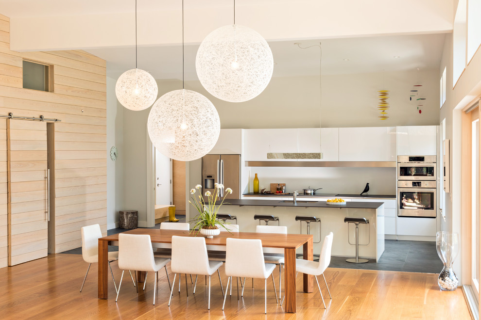 Ispirazione per una grande sala da pranzo aperta verso la cucina contemporanea con pareti beige, pavimento in legno massello medio e pavimento marrone