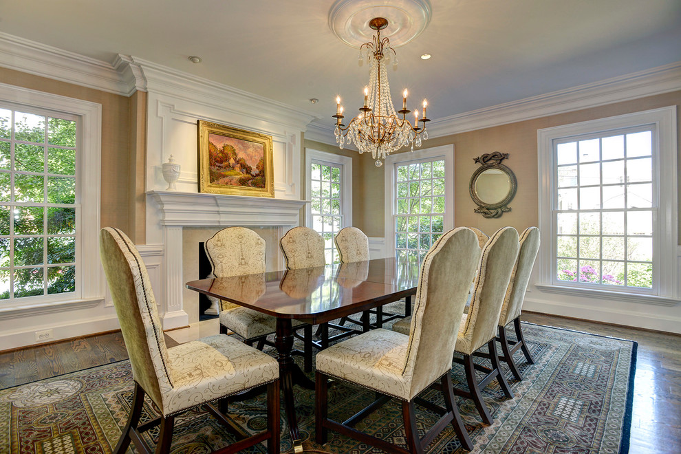 This is an example of a classic enclosed dining room in DC Metro with beige walls, a standard fireplace, medium hardwood flooring and a stone fireplace surround.