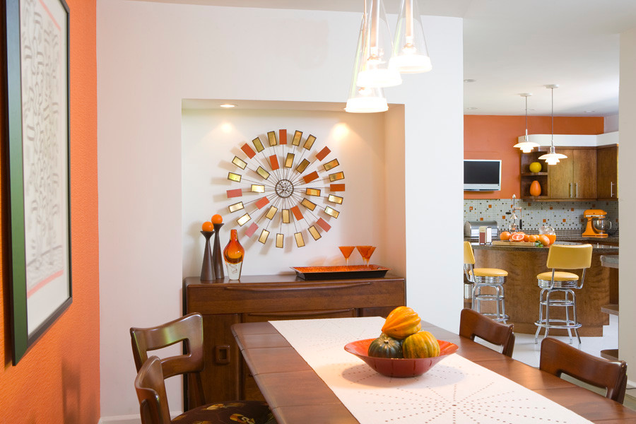 Cette image montre une petite salle à manger ouverte sur le salon minimaliste avec un mur orange, aucune cheminée et un sol beige.