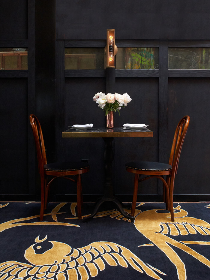 Esempio di una sala da pranzo aperta verso la cucina minimal con pavimento nero, pareti nere e moquette