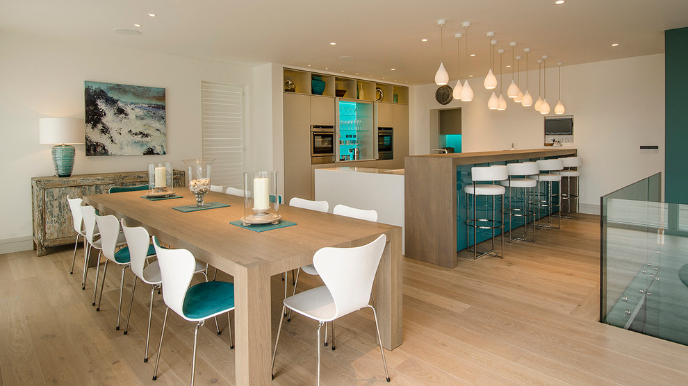 Esempio di una sala da pranzo aperta verso la cucina contemporanea di medie dimensioni con pareti bianche e parquet chiaro