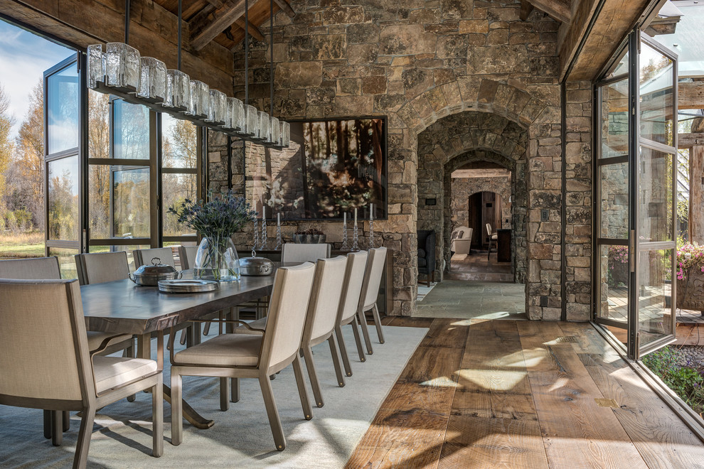 Cette image montre une grande salle à manger ouverte sur le salon chalet avec un mur marron, parquet foncé et aucune cheminée.