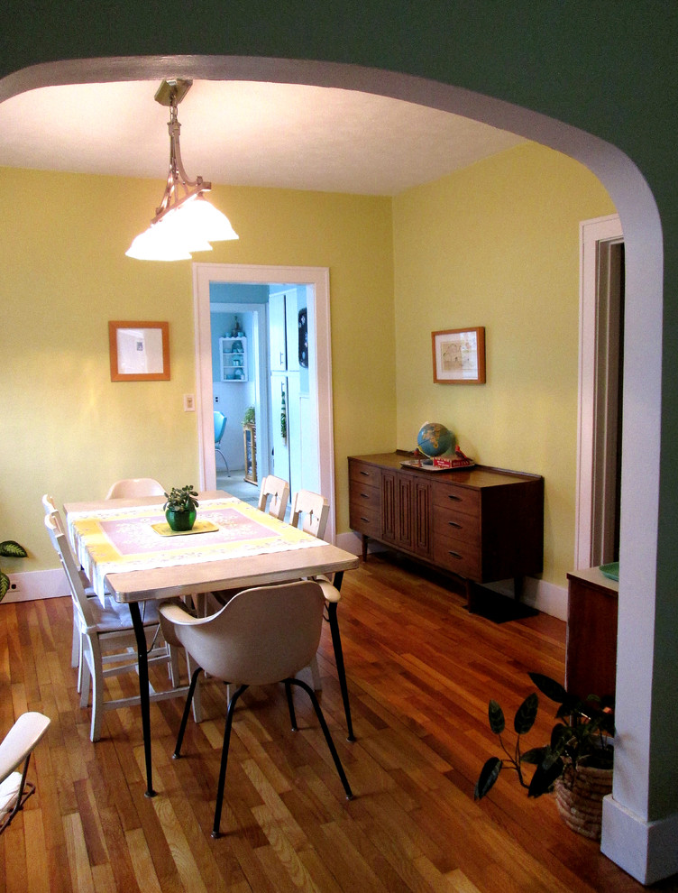 На фото: кухня-столовая в стиле фьюжн с желтыми стенами и паркетным полом среднего тона с