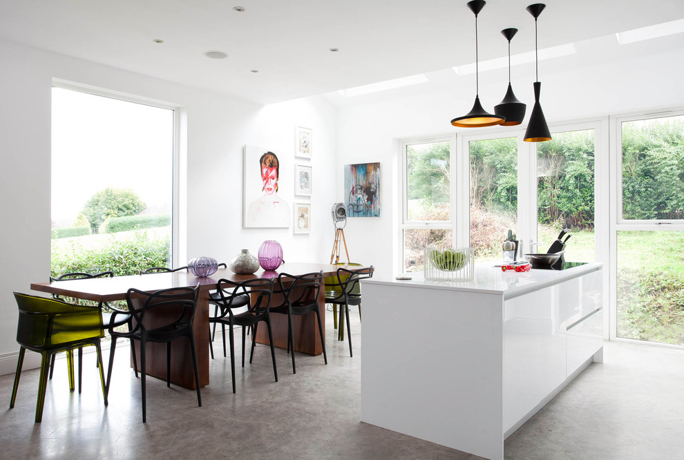 Ispirazione per una grande sala da pranzo aperta verso la cucina minimal con pavimento in cemento e pavimento grigio