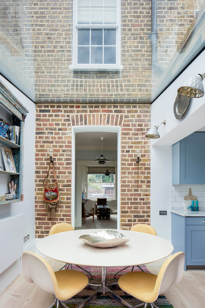 Esempio di una piccola sala da pranzo aperta verso la cucina tradizionale con parquet chiaro, pavimento beige e pareti rosse