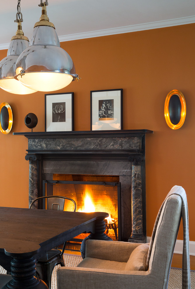 ブリッジポートにあるラグジュアリーな広いトランジショナルスタイルのおしゃれな独立型ダイニング (オレンジの壁、無垢フローリング、標準型暖炉、石材の暖炉まわり) の写真