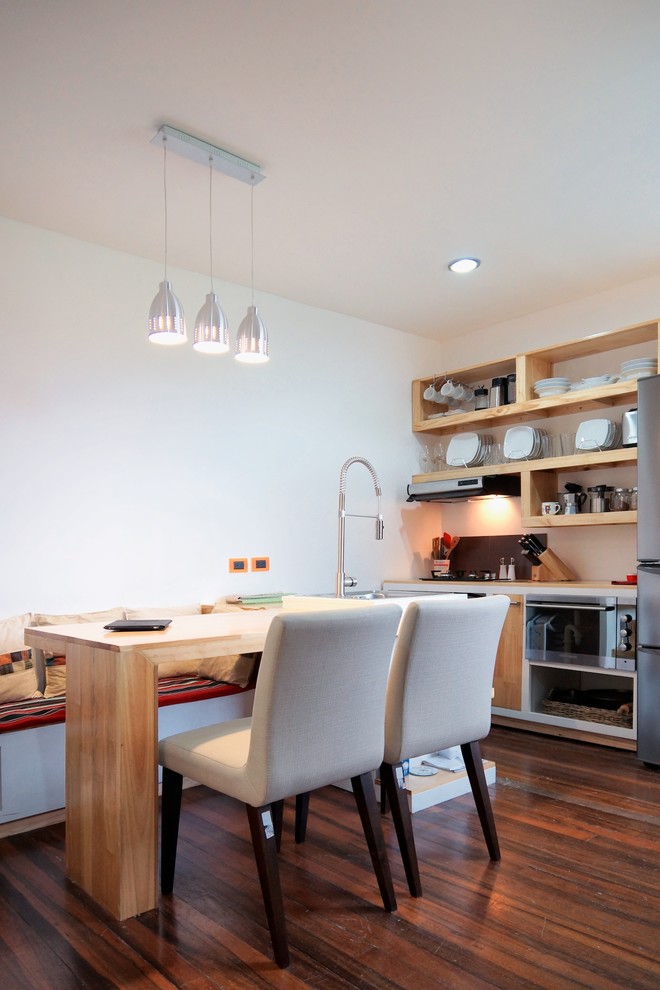 Cette photo montre une petite salle à manger ouverte sur le salon exotique avec un mur blanc et un sol en bois brun.