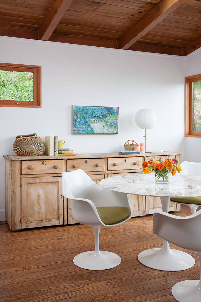 Example of a mid-century modern medium tone wood floor dining room design in San Francisco with white walls