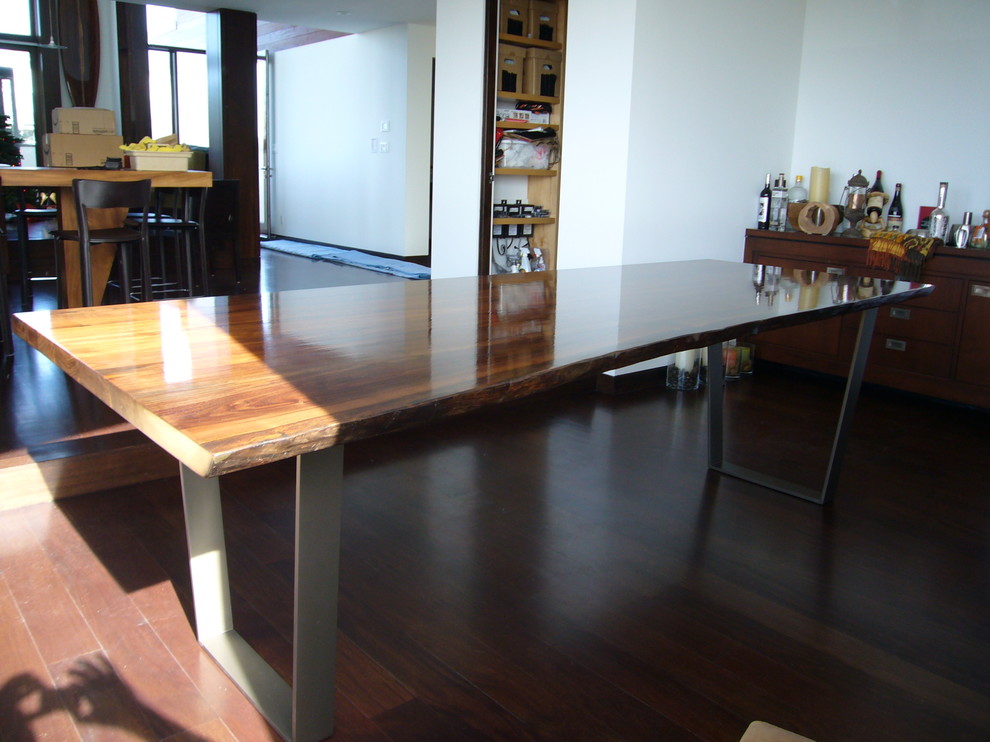 Immagine di una grande sala da pranzo aperta verso la cucina minimal con pareti bianche e pavimento in legno massello medio