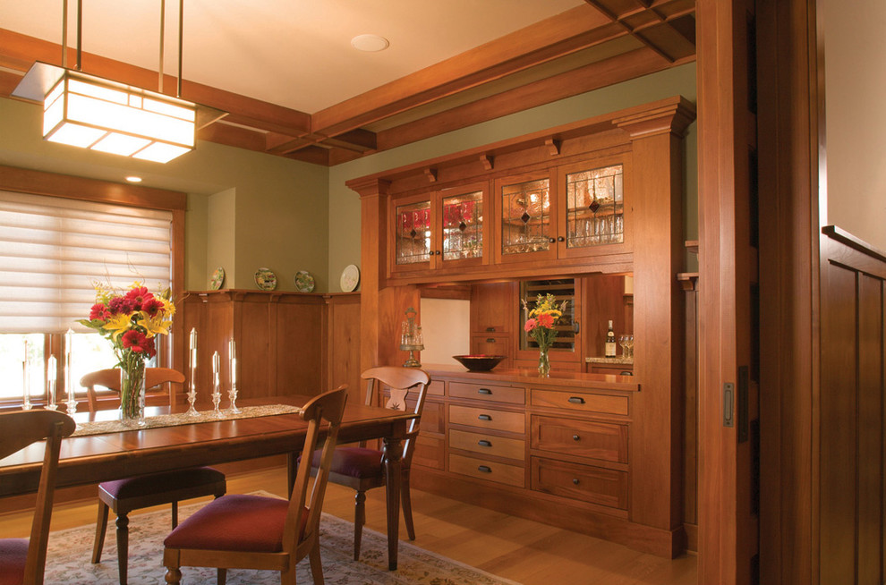 Exemple d'une salle à manger craftsman avec un mur vert et un sol en bois brun.