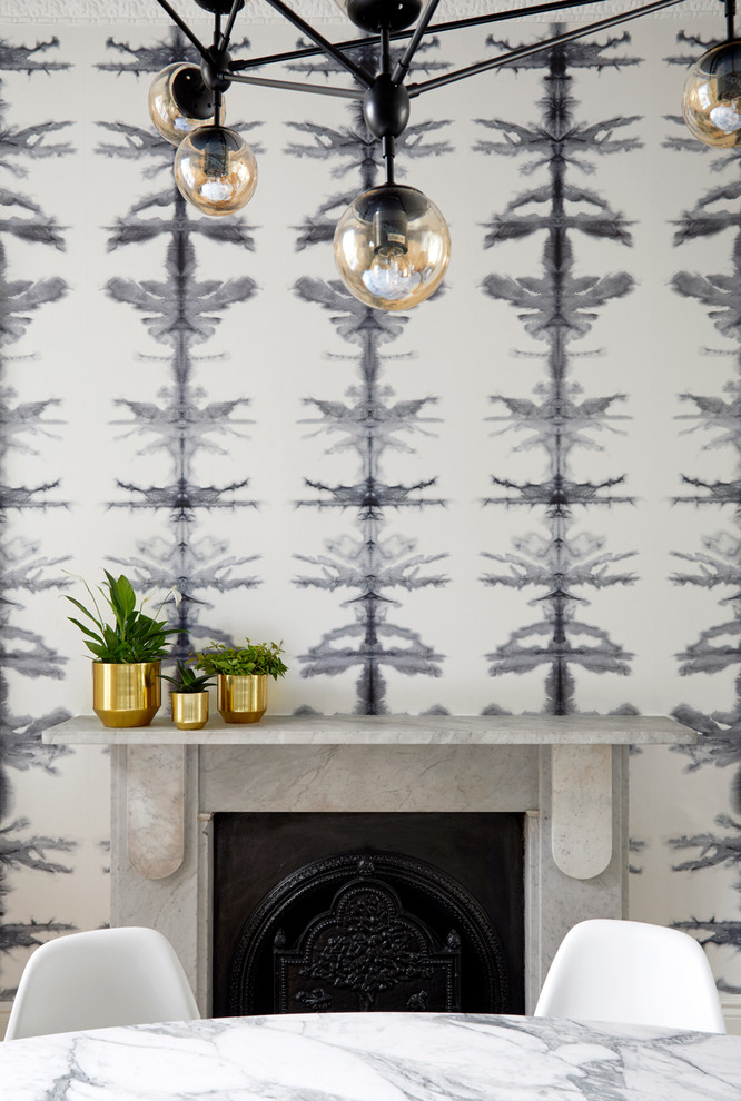 Großes Stilmix Esszimmer mit grauer Wandfarbe, braunem Holzboden, Kamin und Kaminumrandung aus Stein in London