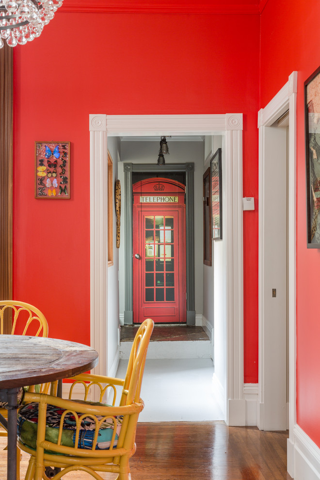 Ispirazione per una sala da pranzo eclettica di medie dimensioni con pareti rosse e pavimento in legno massello medio