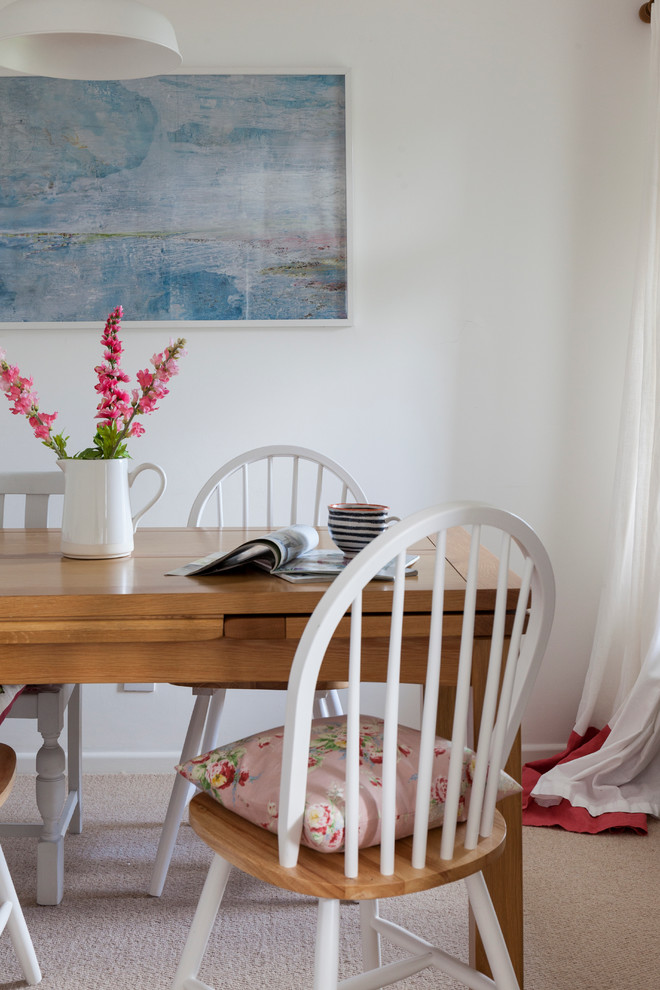 Foto di una piccola sala da pranzo aperta verso il soggiorno country con pareti bianche e moquette