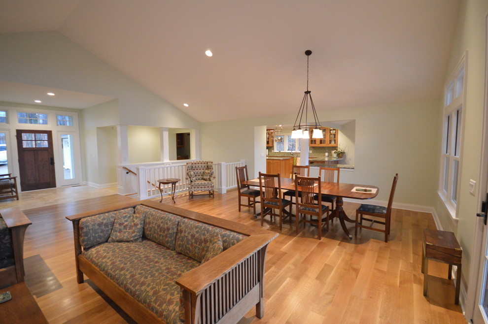 Immagine di una grande sala da pranzo aperta verso il soggiorno stile americano con parquet chiaro e pareti bianche