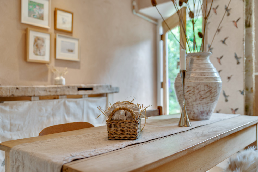 Источник вдохновения для домашнего уюта: маленькая столовая в стиле неоклассика (современная классика) с с кухонным уголком, розовыми стенами, деревянным полом, стандартным камином, фасадом камина из штукатурки и белым полом для на участке и в саду