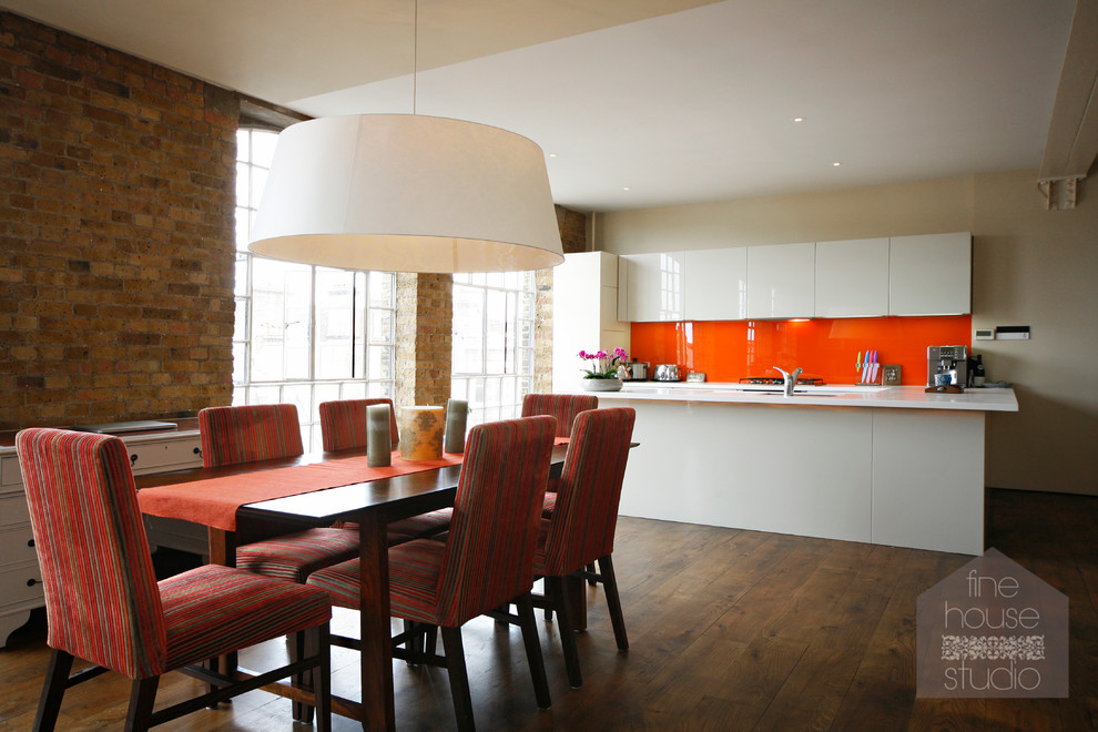 Industrial kitchen/dining room in London with beige walls and dark hardwood flooring.