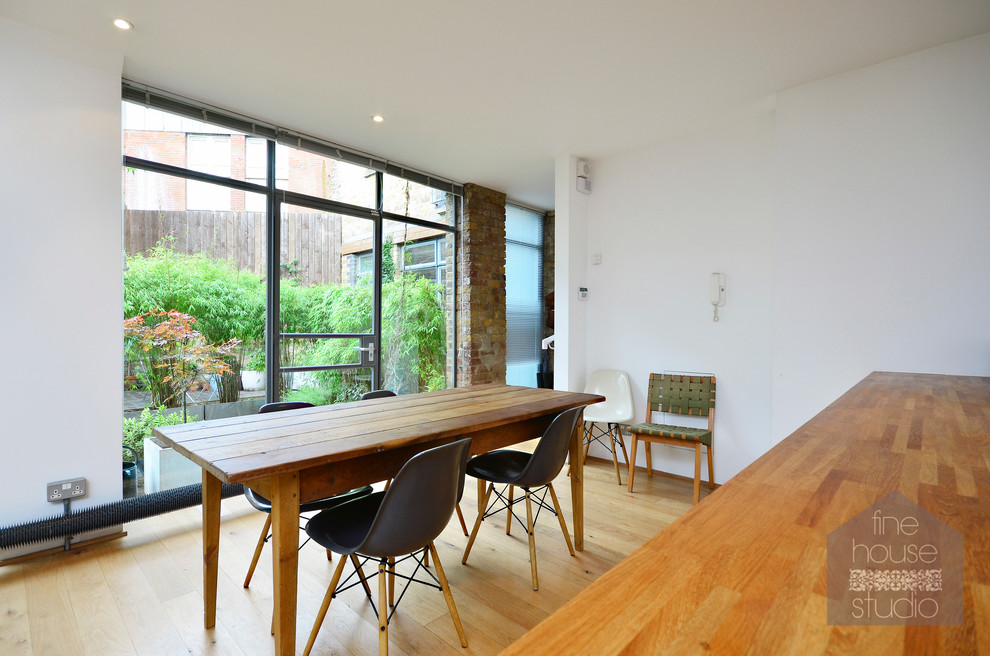 Photo of an urban kitchen/dining room in London with white walls and dark hardwood flooring.