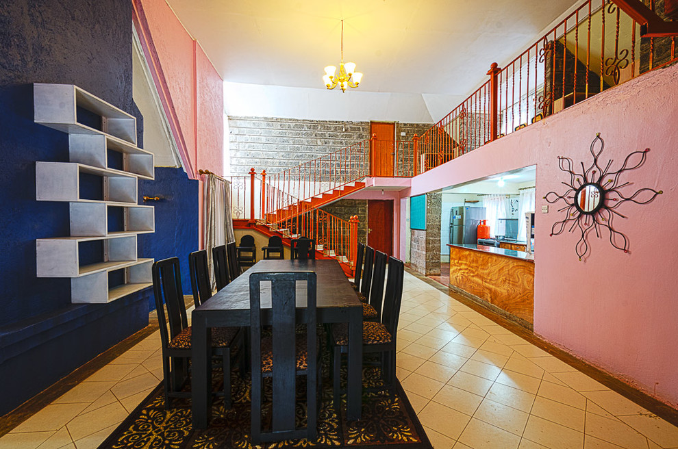 Foto di una grande sala da pranzo aperta verso la cucina boho chic con pareti multicolore, pavimento con piastrelle in ceramica, nessun camino e pavimento beige