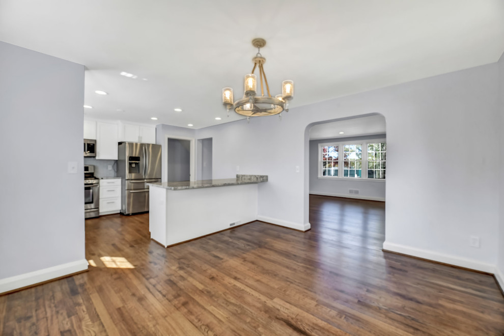 Immagine di una grande sala da pranzo aperta verso la cucina chic con pareti grigie, pavimento in legno massello medio e pavimento marrone