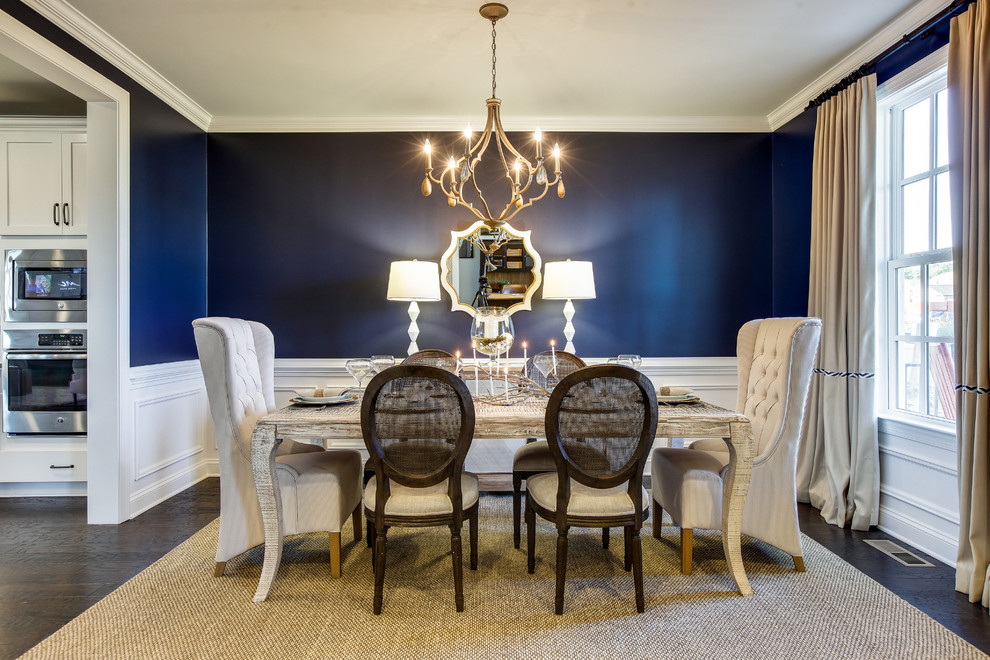 Immagine di una sala da pranzo aperta verso la cucina tradizionale con pareti blu, parquet scuro e pavimento marrone