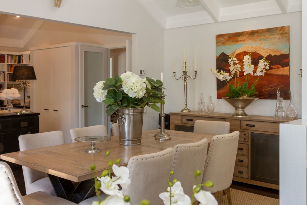 Foto di un'ampia sala da pranzo aperta verso la cucina tradizionale con pareti bianche, parquet scuro, nessun camino e pavimento marrone