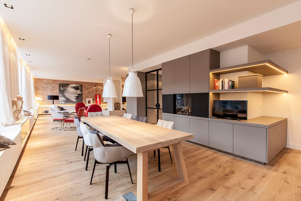 Photo of a contemporary open plan dining room in Amsterdam with beige walls and light hardwood flooring.