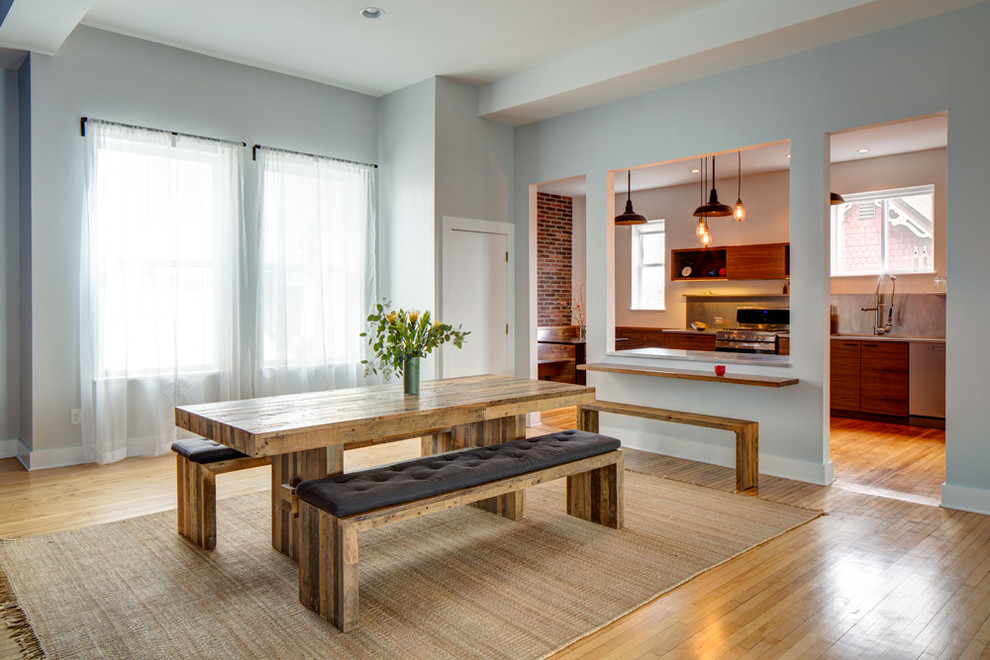 Aménagement d'une salle à manger contemporaine avec un mur gris et un sol en bois brun.
